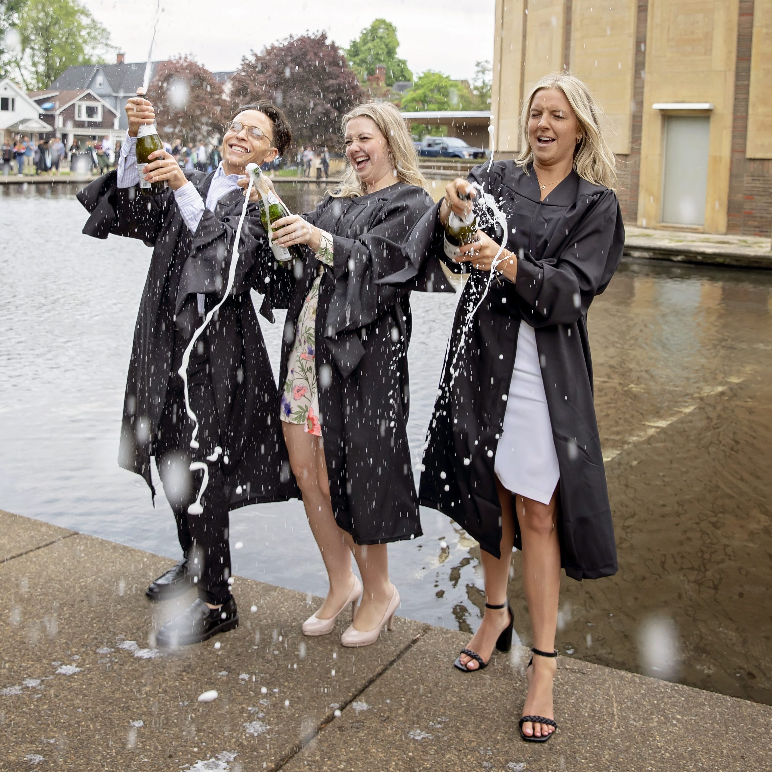 Graduates celebrating with champagne outside of Kleinhans Music Hall