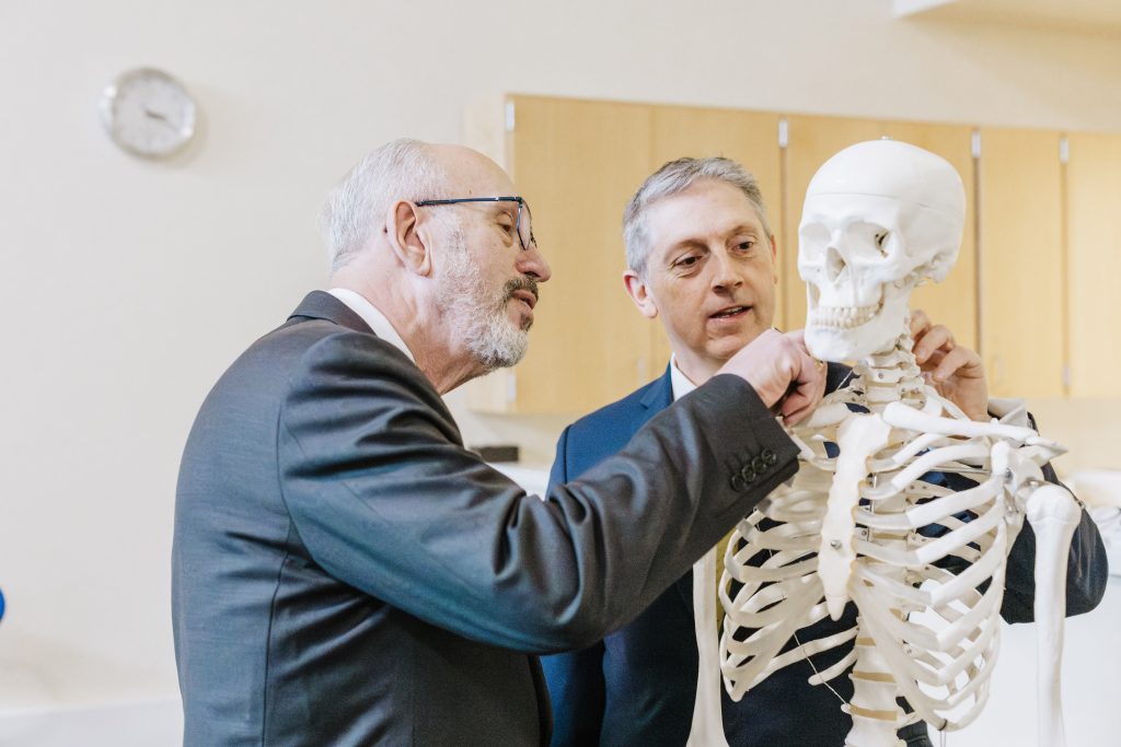 Dr. Greg Ford and Scott Bieler review a skeleton at the opening of the Scott Bieler College of Health Professions