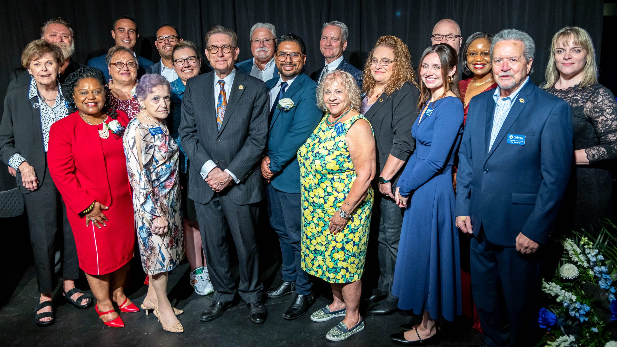 Dr. Olson and Dr. Brogan stand with a group of distinguished alumni, past and present