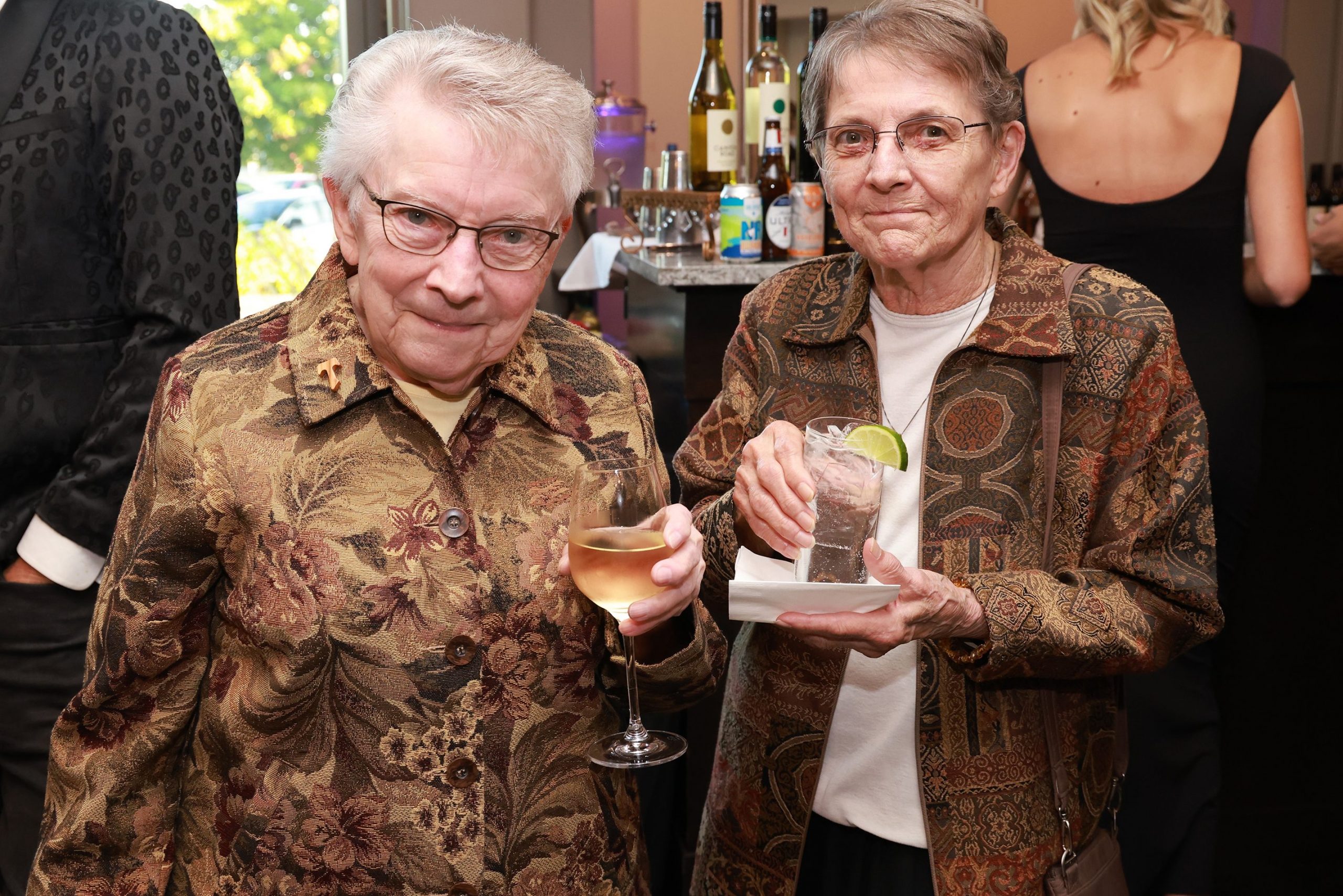Two women standing together with drinks in their hands