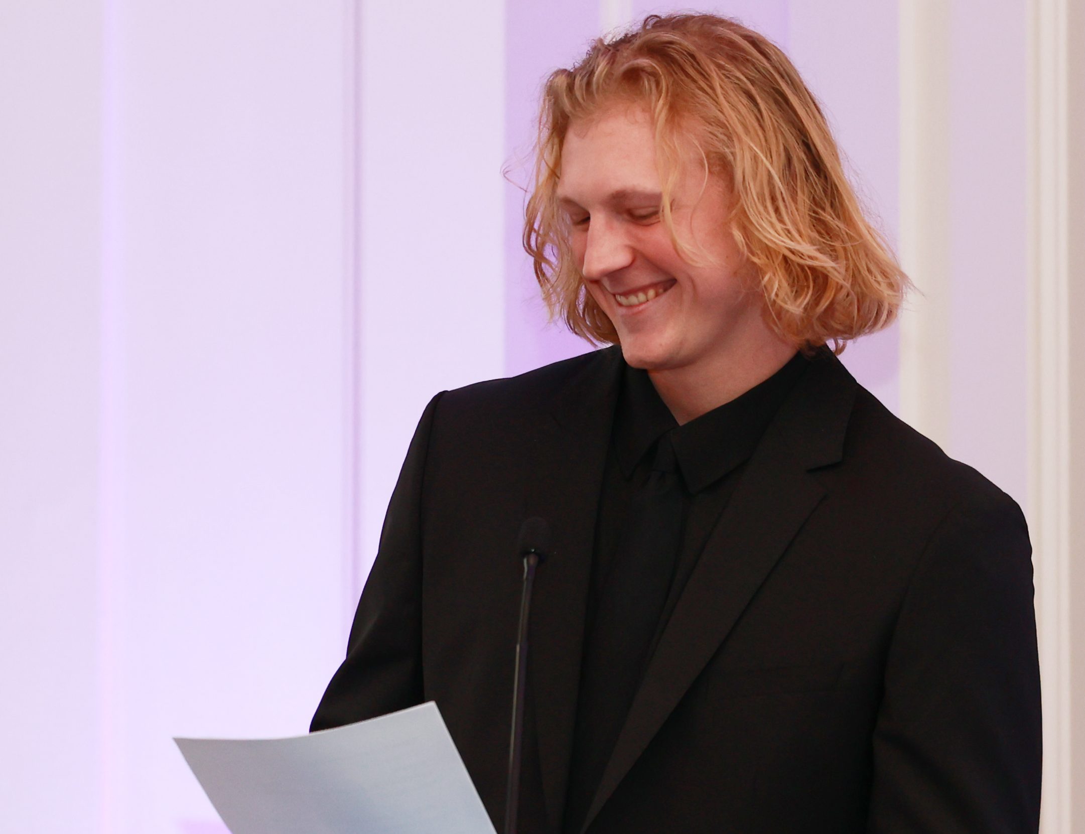 Male student standing at a podium giving a speech
