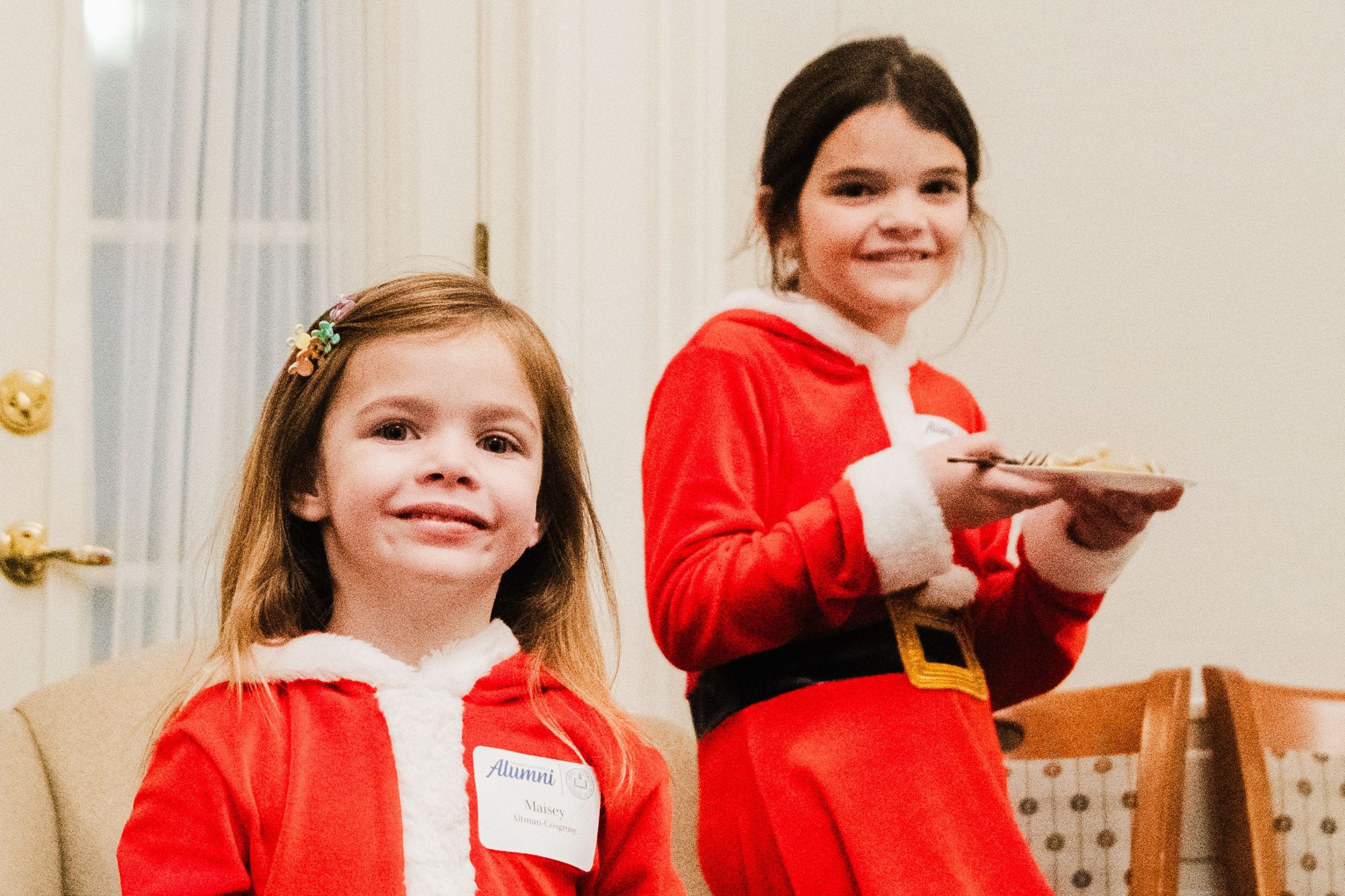 Two young girls dressed in Santa outfits